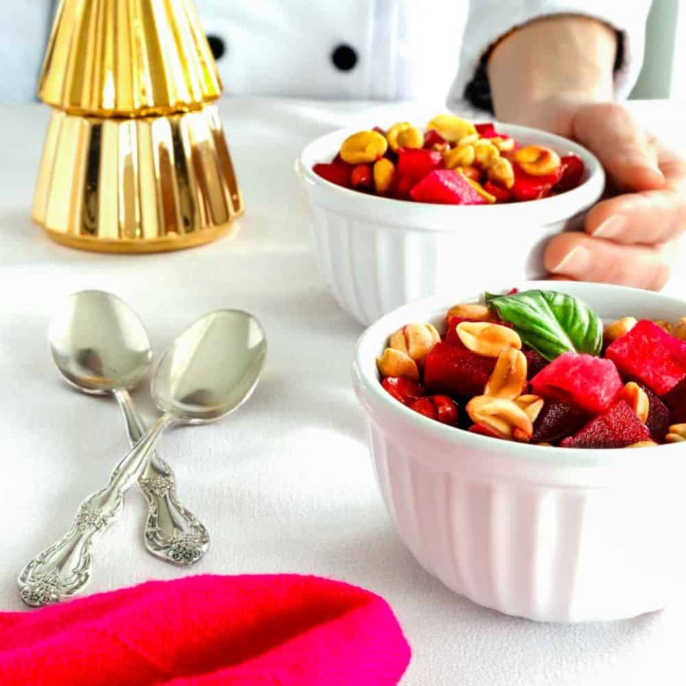Christmas fruit salad in two bowls. There's a chef in the background.