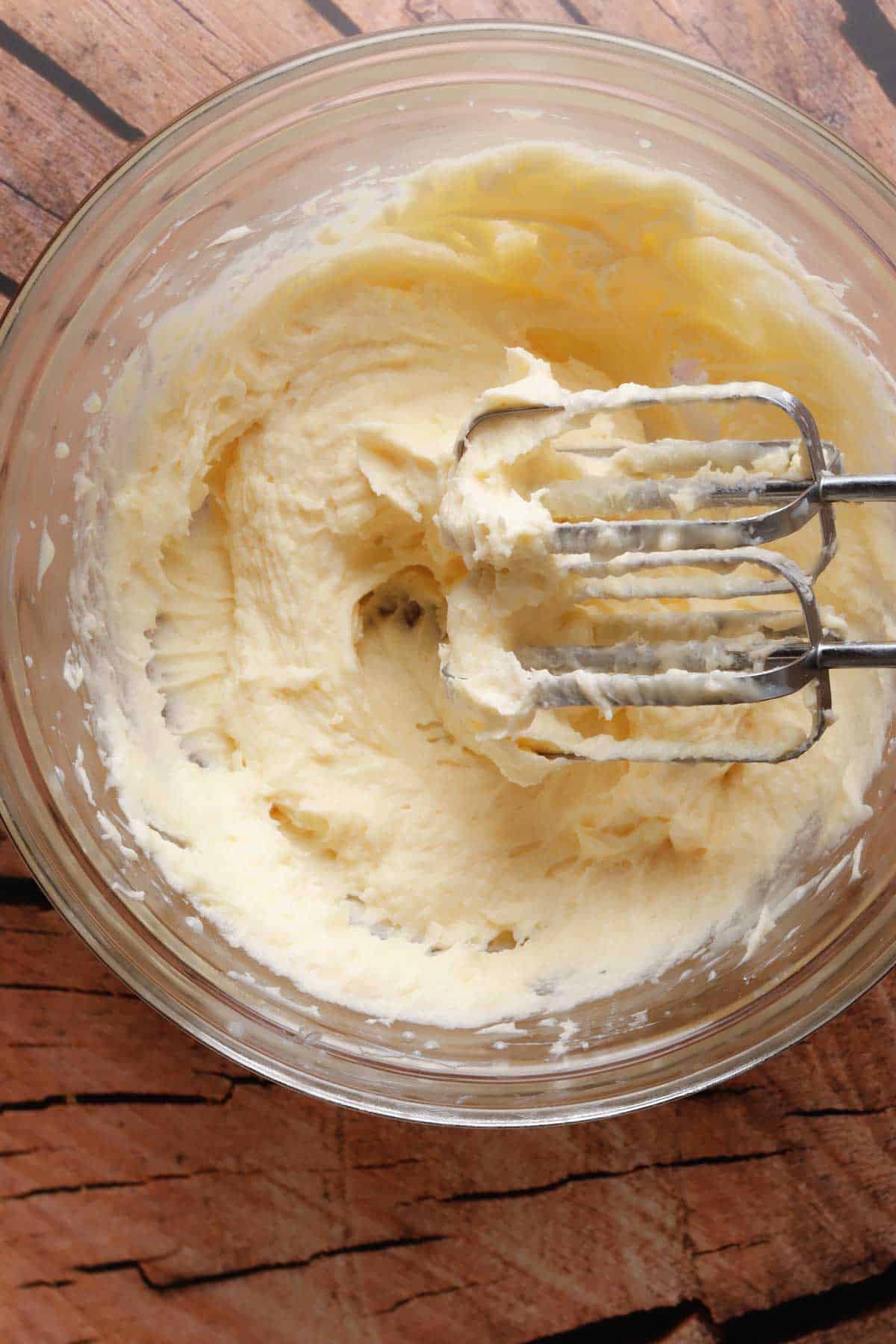 Butter, sugar, condensed milk and vanilla extract mixed for preparing the sweet pineapple tamales.