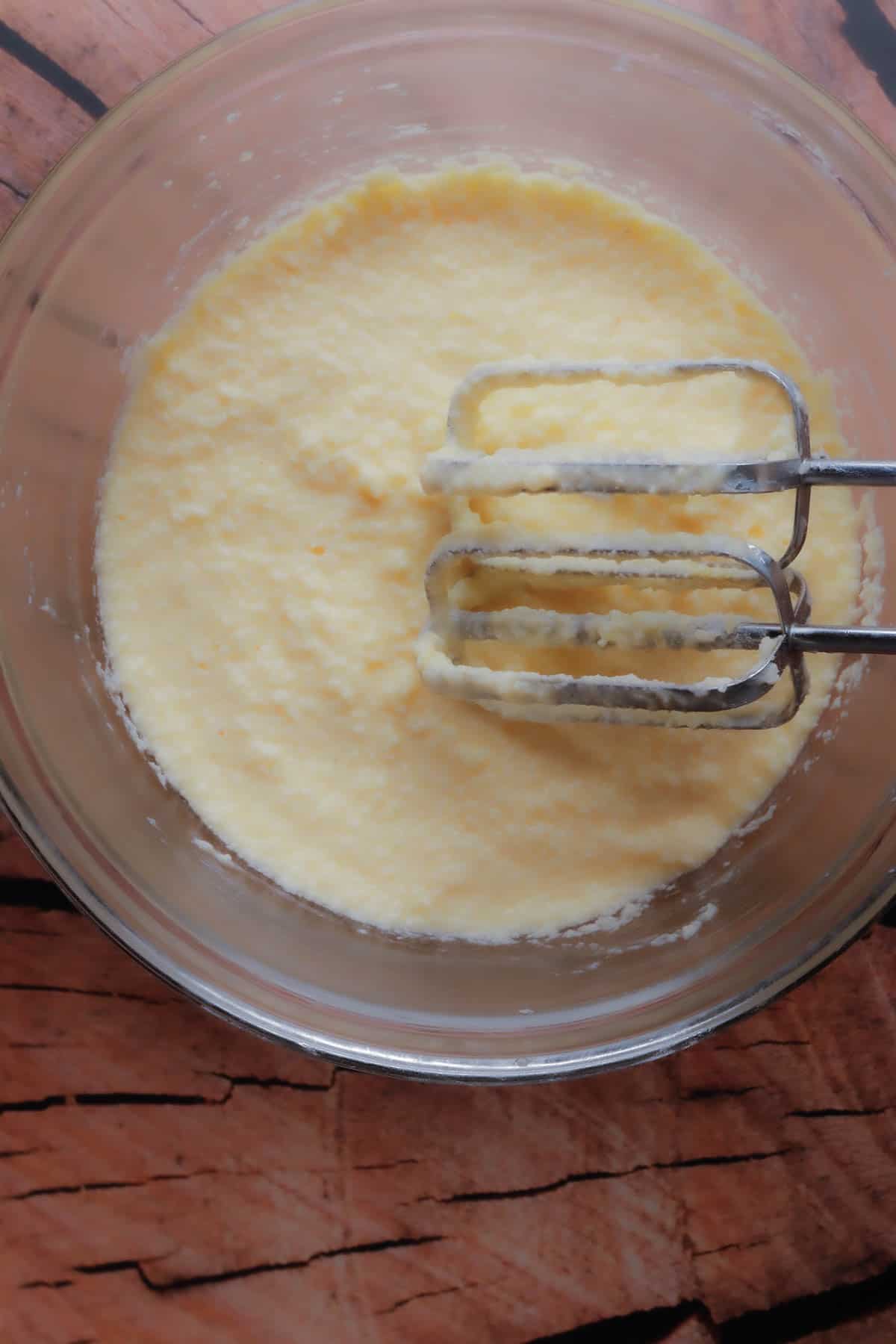 Butter, sugar, condensed milk, vanilla extract and eggs mixed for preparing the sweet pineapple tamales.