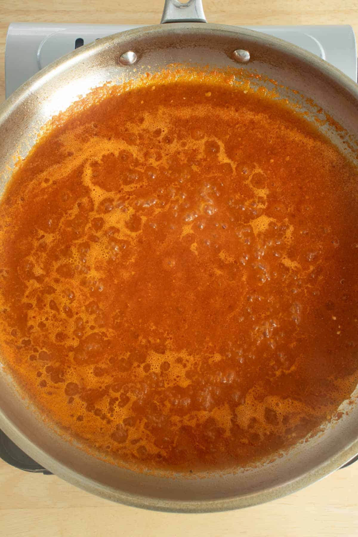 Sauce in pan for baked Mexican meatballs.