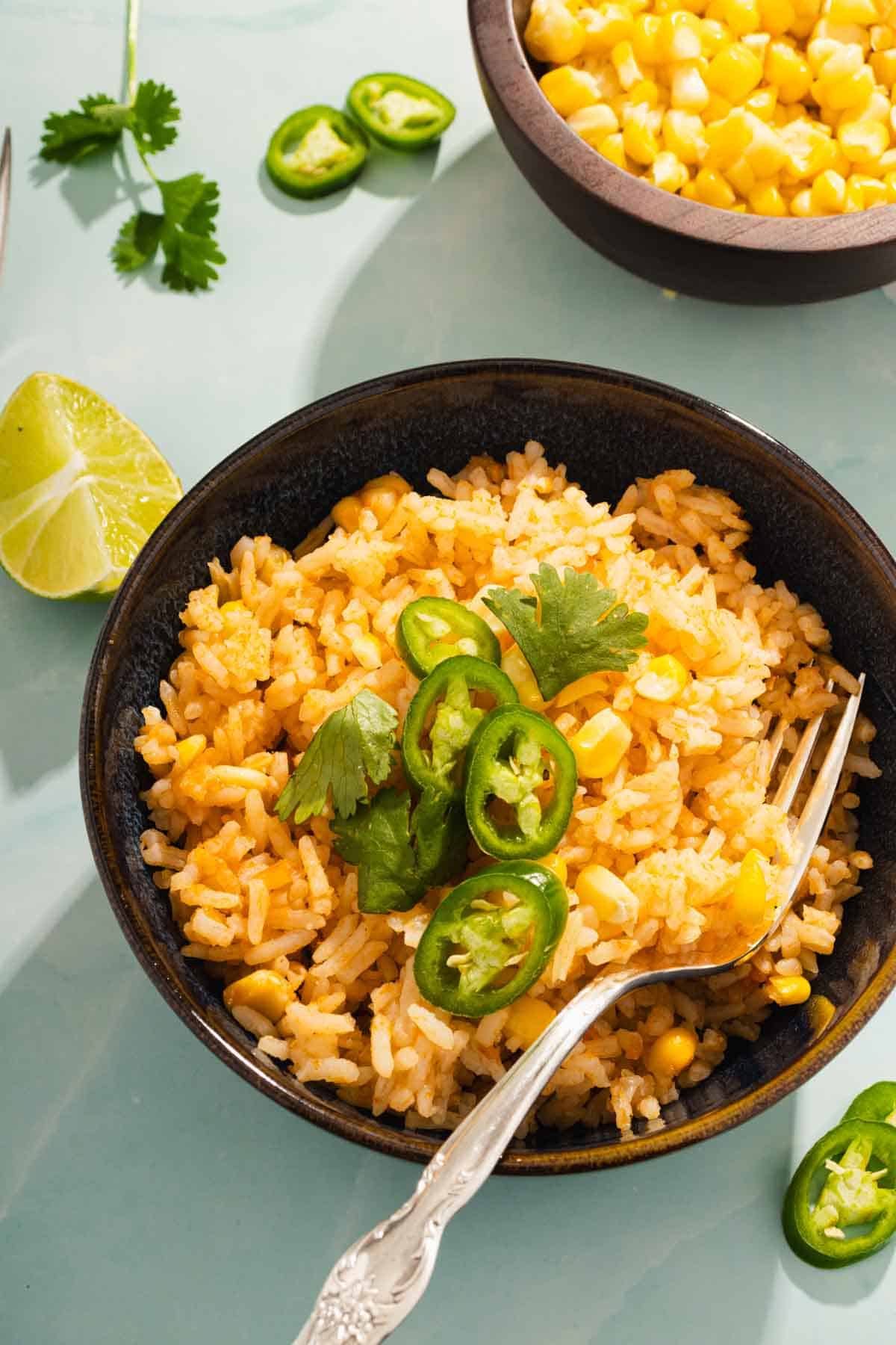 Red Mexican Rice served in a bowl and with a lime wedge on the side.