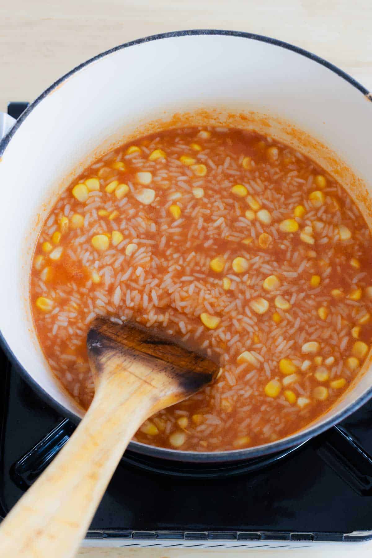 Chicken broth and corn in pot.