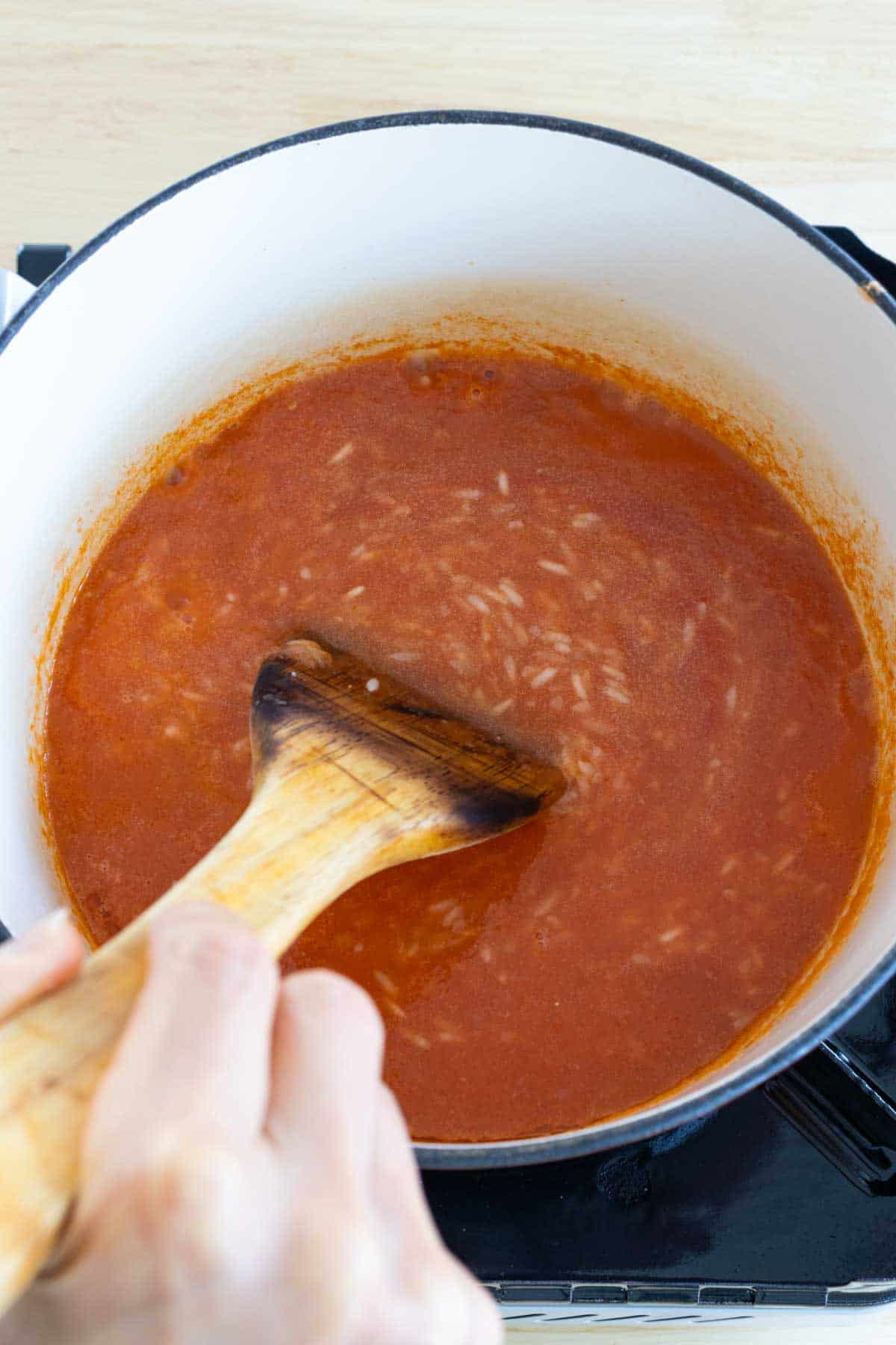 Blended tomato sauce in pot with rice.