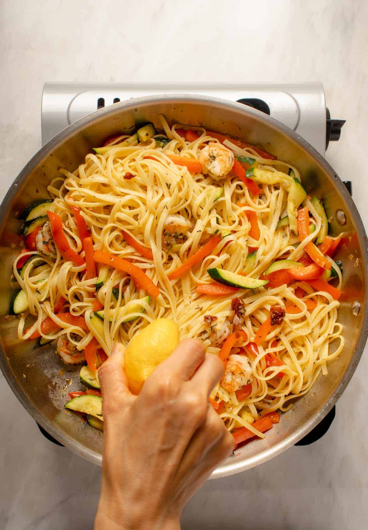 Adding lemon juice and zest to finish pasta.