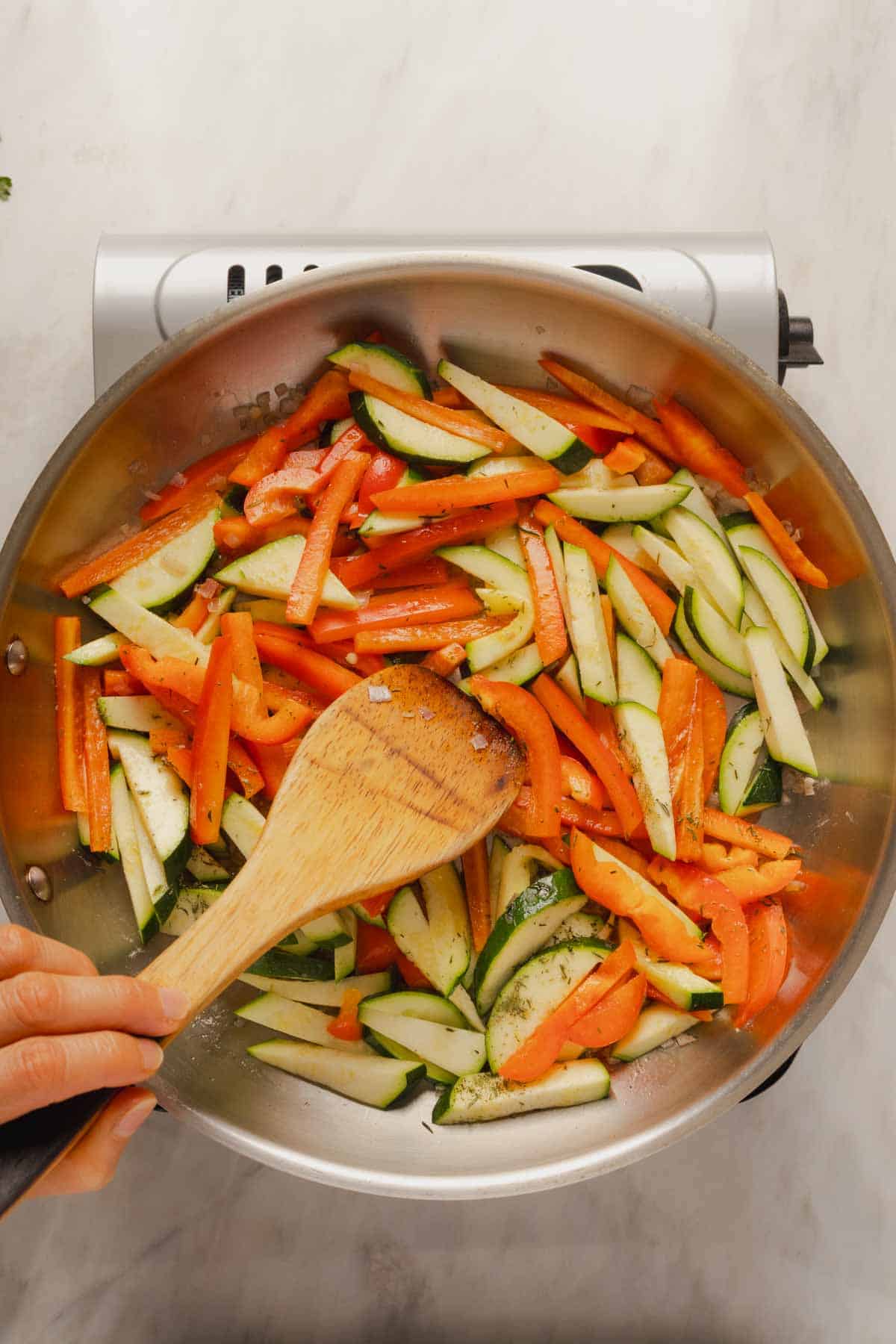 Cooking the zucchini and bell pepper for the pasta.